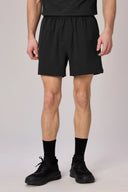 Men's charcoal basic athletic shorts with elastic waistband, modeled standing