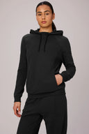 Woman wearing charcoal grey tracksuit hoodie and matching joggers, front view