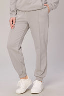 Beige jogger sweatpants with side pockets and cuffed ankles, styled with white sneakers