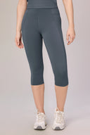 Woman wearing granite grey compression capri leggings and white sneakers