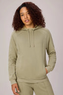 Woman wearing light olive green athleisure tracksuit hoodie with front pocket