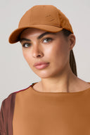 Woman wearing dark suntan athleisure cap and matching activewear top