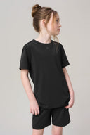 Girl wearing charcoal short sleeve basic tee and matching shorts, neutral background