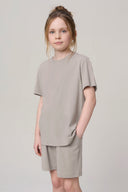 Girl wearing driftwood beige basic tee and shorts athleisure set, neutral background