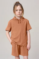 Girl wearing mocha brown hooded tee and matching shorts, casual neutral background