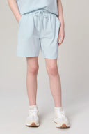 Girl wearing light blue drawstring athleisure shorts with pockets and white sneakers