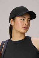 Woman wearing charcoal sports cap and black athleisure tank top