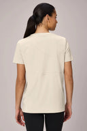 Back view of woman wearing sand beige performance athletic tee with short sleeves