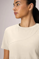 Close-up of woman wearing sand-colored short sleeve athleisure performance tee