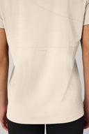 Back view of sand-colored short sleeve athletic tee on person, showing subtle logo detail