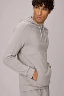 Man wearing a light grey athleisure tracksuit hoodie with drawstrings and kangaroo pocket