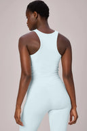 Woman wearing light blue compression sports bra and leggings, back view