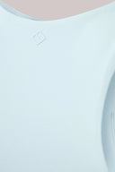 Close-up of light blue seamless compression sports bra with subtle stitched logo detail