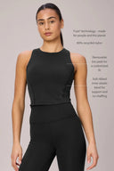 Woman wearing a charcoal high-neck compression sports bra and black leggings, shown front view.