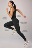 Woman running in charcoal compression leggings and crop top, high rise waistband, features labeled.