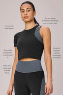 Woman wearing a charcoal grey cropped performance tee with cut-out, mesh sleeve, and high-waisted leggings.