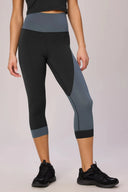 Person wearing black and gray leggings on a plain background