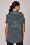 Back view of woman wearing a granite short sleeve pima hoodie with mesh panel