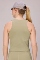 Woman wearing light green compression athletic tank top and cap, seen from the back