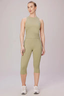 Woman wearing light green sleeveless compression top and matching high-waist cropped leggings