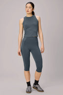 Woman wearing granite blue sleeveless compression top and high-waisted athletic capris