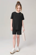 Girl wearing charcoal basic tee and shorts set, holding a water bottle, neutral background