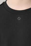 Close-up of charcoal basic tee for girls, soft fabric, crew neck, subtle chest logo