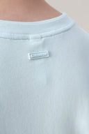 Close-up of light blue crewneck tee with back neck Seissense label, minimalist style