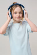 Girl in light blue basic tee and blue headphones, smiling in athleisure clothing