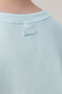 Close-up of light blue athletic tee back collar with Seissense logo patch detail