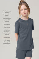 Girl wearing granite grey short-sleeve athletic tee and shorts, standing against light background.