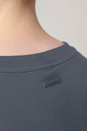 Close-up of gray performance tee back neckline with logo patch detail
