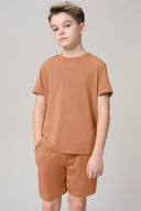 Boy wearing mocha brown short sleeve activewear tee and matching shorts