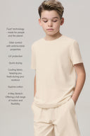 Boy wearing sand-colored basic tee and shorts, standing with hands in pockets, features listed
