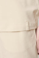 Close-up of beige athleisure tee and shorts set featuring soft, smooth fabric texture.