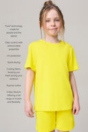 Girl wearing bright yellow short-sleeve tee and shorts, athletic comfort fit