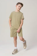 Boy wearing khaki short-sleeve activewear t-shirt and shorts with sneakers