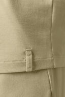 Close-up of light beige boys' basic tee with subtle fabric tag and soft texture detail