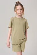 Girl wearing a light olive green short-sleeve tee and shorts athleisure set