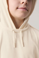 Close-up of a child wearing a sand-colored hooded tee with drawstrings