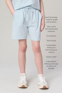 Girl wearing light blue athletic shorts with drawstring, side pockets, and white sneakers