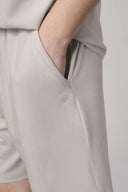 Close-up of light beige boys’ athleisure shorts with side pocket and relaxed fit.