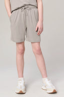 Girl wearing driftwood beige athleisure shorts with drawstring and pockets