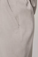 Close-up of light beige girls' athleisure shorts pocket with subtle logo detail