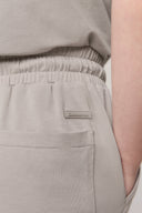 Close-up of beige girl's athleisure shorts with elastic waistband and back pocket