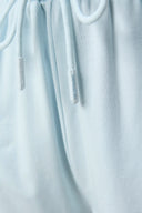 Close-up of light blue athletic shorts drawstring with textured fabric detail