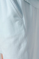 Close-up of light blue athletic shorts with side pocket and minimal logo detail.