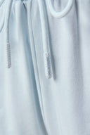 Close-up of light blue athletic shorts drawstring with subtle branding detail.