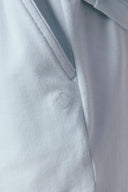 Close-up of light blue athleisure shorts pocket and logo, soft eco-friendly fabric