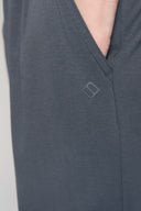 Close-up of granite grey boys' athletic shorts with hand in pocket and subtle logo
